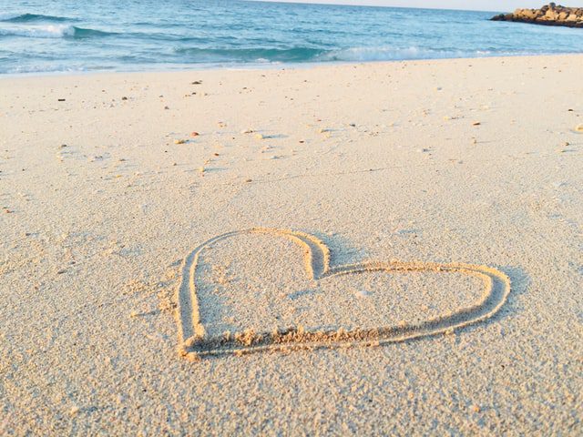 heart drawn in sand at a beach