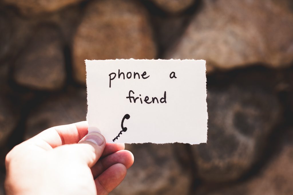 hand holding a "phone a friend" card